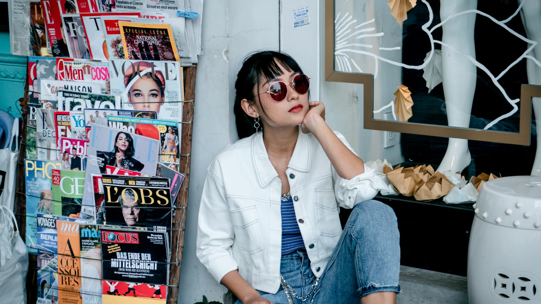 woman sitting near magazine stand